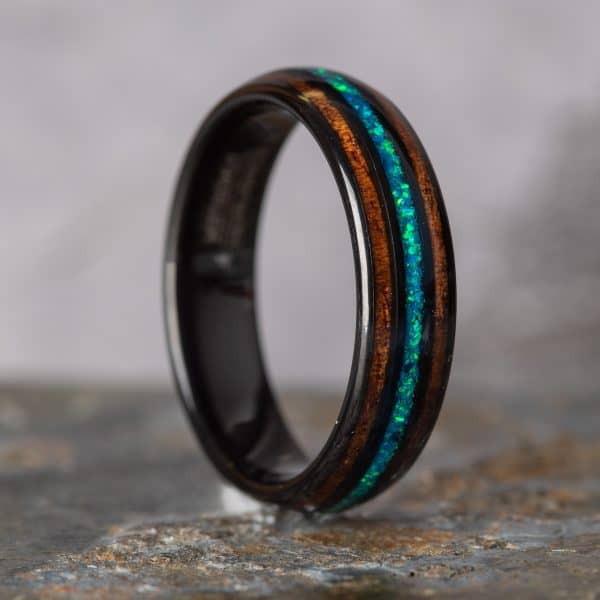 Opal and Koa Wood Black Tungsten Ring standing on side